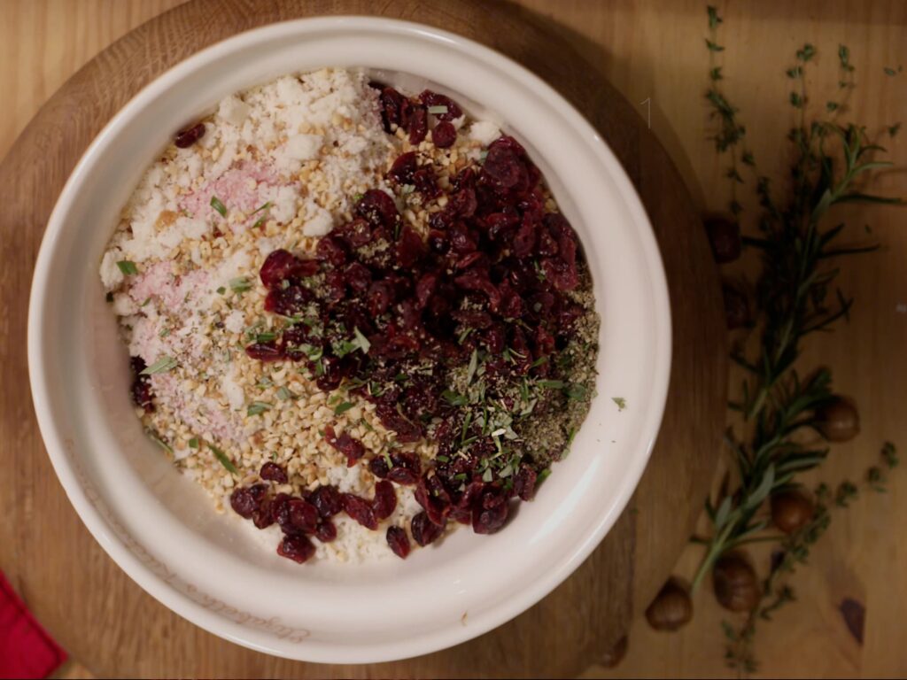 Image of cranberry and hazelnut pork sausagemeat stuffing in a bowl ready to be mixed together by hand.