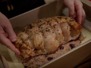 Image of roasted cooled turkey butterfly on top of stuffing on top of puff pastry.