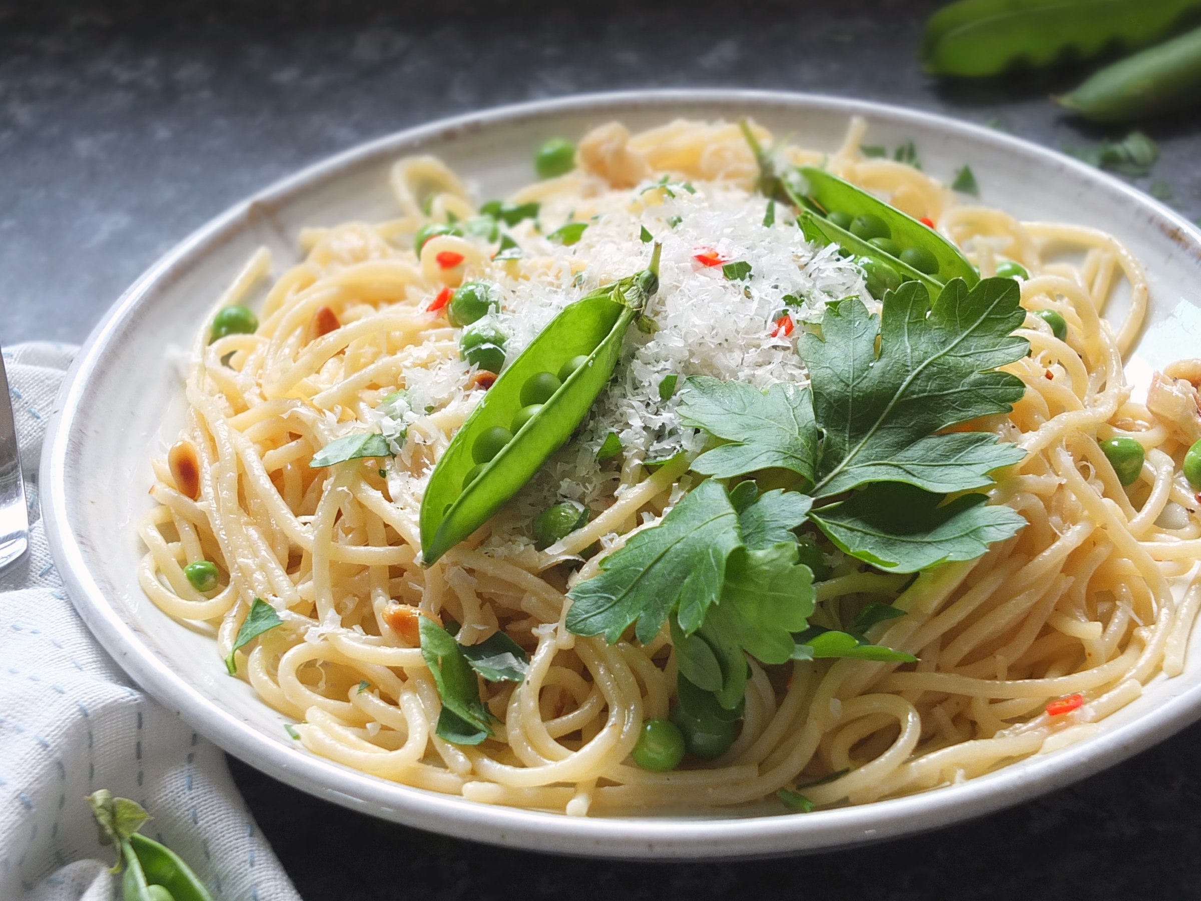 Side on image of finished dish of pasta with green peas.