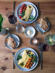 Top down image of a bacon jam omelette served for brunch with wine.