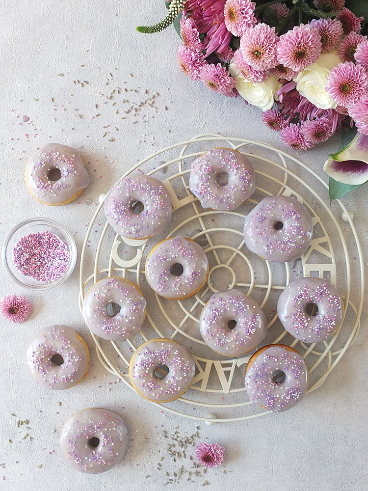 In this easy baked doughnuts recipe, lemon zest, lemon extract and lavender flowers are combined to make a delicious, fluffy, moist, perfectly baked doughnut with a lavender icing sugar glaze. #doughnuts #bakeddoughnuts #lavender #lemondoughnut #lemondonut #bakeddonut