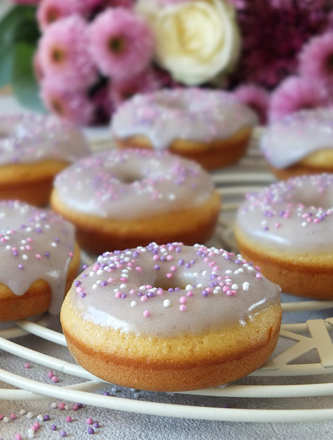 In this easy recipe, lemon zest, lemon extract and lavender flowers are combined to make a delicious, fluffy, moist, perfectly baked doughnut with a lavender icing sugar glaze. #doughnuts #bakeddoughnuts #lavender #lemondoughnut #lemondonut #bakeddonut
